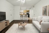 Chic apartment living room with elegant white sofa, cozy coffee table, and a modern open-plan kitchen featuring stylish bar stools and wood accents.