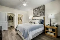 Inviting bedroom with modern decor, highlighting a cozy bed, stylish artwork, and ample closet space.