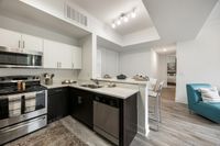 Modern open kitchen design with stainless steel appliances, elegant dining area, and cozy seating, exuding contemporary charm and style.