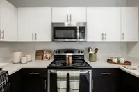 Modern kitchen with sleek white cabinets, stainless steel appliances, and stylish countertop decor.