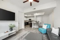Modern open-concept living area with stylish furnishings, a sleek kitchen, and elegant decor, perfect for contemporary living.