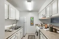Chic and cozy kitchen with modern white cabinets, electric stove, and elegant decor, exuding a warm and inviting atmosphere.