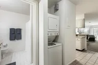 Modern apartment interior showcasing a bright bathroom, convenient in-unit laundry, and inviting open-plan living space.