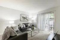 Inviting living room with sleek leather sofas, natural light from large sliding doors, and elegant decor.