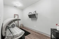Modern spa room with tanning bed, sleek shelf, and elegant decor, perfect for relaxation and rejuvenation.