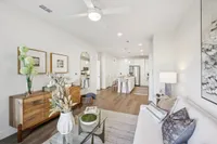 Chic open-plan living room with elegant decor, featuring a modern kitchen with sleek appliances and a cozy seating area perfect for relaxation.