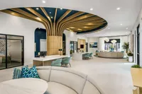 Luxurious apartment lobby with striking modern design, featuring a unique ceiling structure, chic seating areas, and elegant decor accents.