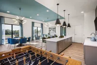 Modern open-concept apartment featuring a stylish kitchen island, chic dining area, and a cozy gaming corner with foosball table.