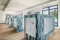 Contemporary mailroom with elegant blue-tiled mailbox units, sleek pendant lighting, and large windows offering natural light.
