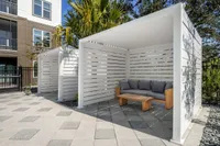 Chic outdoor lounge area with modern pergolas, comfortable seating, and lush greenery, ideal for relaxation.