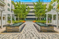 Elegant courtyard with modern water features, lush greenery, and comfortable seating, perfect for relaxation and gatherings.
