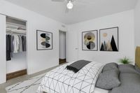 Modern bedroom with elegant geometric art, cozy bedding, and a spacious closet, perfect for stylish living.