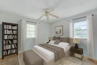 Inviting bedroom with cozy decor, elegant wooden bookshelf, and soft natural light through large windows.