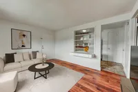 Inviting living room with modern decor, plush white sofa, and elegant wooden flooring, perfect for relaxation.