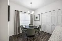 Charming dining area with modern round table, upholstered chairs, stylish decor, and elegant lighting, creating an inviting atmosphere for memorable meals.