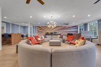 Vibrant community lounge with modern seating, dynamic wall art, and ample natural light, perfect for social gatherings.