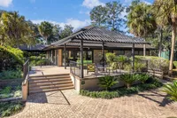 Charming outdoor area with lush landscaping and a stylish modern patio, perfect for relaxation and outdoor gatherings.