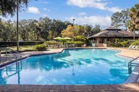 Inviting pool area surrounded by lush greenery and stylish lounge chairs, perfect for relaxation and outdoor gatherings.