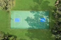 Aerial view of a vibrant outdoor basketball court surrounded by lush greenery, offering a perfect recreational escape.
