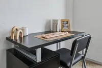 Modern home office setup with sleek black desk, comfortable chair, and chic decor items creating an inviting workspace.