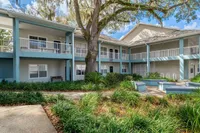 Charming two-story apartment complex with inviting balconies and lush greenery in a serene courtyard setting.
