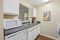 Charming kitchen featuring sleek countertops, modern microwave, and vibrant decor.