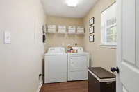Charming laundry room featuring modern washer and dryer, with efficient storage solutions and elegant decor accents.