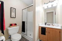 Elegant bathroom featuring a modern shower, vanity with ample storage, and stylish decor.
