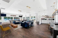 Modern and inviting community lounge featuring elegant lighting, comfortable seating, and a view of the outdoor pool area.