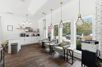 Chic and inviting communal space with modern kitchen facilities, cozy seating, and large windows offering a serene outdoor view.