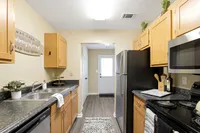 Charming kitchen with modern appliances, wood cabinets, and sleek countertops, offering a warm and inviting atmosphere.