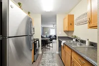 Contemporary kitchen with stainless steel appliances, sleek countertops, and a view into a cozy living area with natural light.