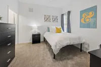 Bright and cozy bedroom with elegant decor, featuring a comfortable bed, modern furniture, and vibrant wall art.