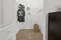 Spacious walk-in closet with sleek shelving, cozy carpeting, and ample storage space.