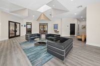 Elegant lounge area with modern black sofas and glass coffee table surrounded by a serene atmosphere and stylish decor.