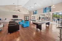 Modern communal space featuring sleek seating, expansive windows, and recreational amenities with poolside view.