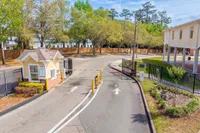 Inviting entrance to a vibrant community with lush greenery and secure gated access.