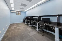 Chic and modern workspace with sleek black desks, ergonomic chairs, and soft blue walls creating an inviting atmosphere.