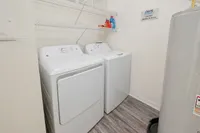 Efficient laundry space with modern washer and dryer, featuring stylish shelving for organization.