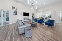 Chic open-concept living space with stylish furniture, modern lighting, and a sleek kitchen area, offering comfort and elegance.