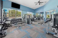 Modern fitness center with state-of-the-art equipment, ample natural light, and a mirrored wall for an invigorating workout experience.
