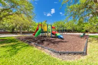 Inviting outdoor playground featuring colorful slides and climbing structures surrounded by lush greenery, perfect for family fun.