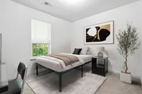 Bright and cozy bedroom with modern decor, featuring a comfortable single bed, stylish bedside table, and elegant artwork on the wall.