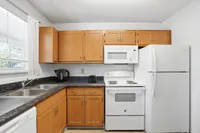Charming kitchen with sleek countertops, modern appliances, and elegant wooden cabinetry.