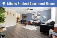 Stylish student apartment living room with modern decor, cozy seating, and open layout connecting to kitchen area.