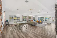 Spacious and inviting living area featuring modern decor, a pool table, and elegant lighting, perfect for entertaining and relaxation.
