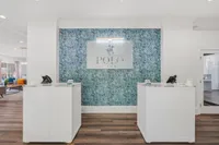 Elegant apartment lobby with a stylish blue patterned accent wall and chic reception desks at Polo Club.