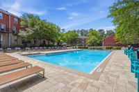 Inviting outdoor pool area surrounded by sun loungers and lush greenery, perfect for relaxation and leisure.