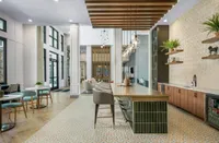 Modern lounge area with elegant lighting, cozy seating, and stylish decor, featuring a chic countertop and vibrant patterned flooring.