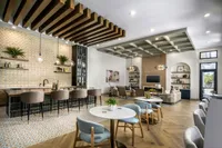 Chic and modern open-concept living and dining area with stylish bar seating, elegant lighting, and cozy lounge space.